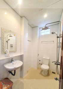a white bathroom with a toilet and a sink at Quan Quan Hotel in Danang