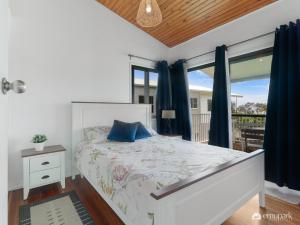 ein Schlafzimmer mit einem weißen Bett und einem Fenster in der Unterkunft Four Palm's in Emu Park