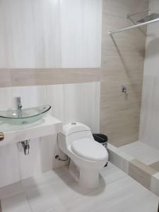 een witte badkamer met een toilet en een wastafel bij Bello Horizonte Departamento in Cuenca