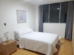 een witte slaapkamer met een bed en een raam bij Bello Horizonte Departamento in Cuenca