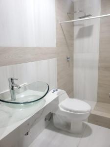 een witte badkamer met een wastafel en een toilet bij Bello Horizonte Departamento in Cuenca
