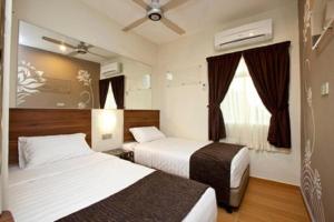 a hotel room with two beds and a window at Tune Hotel - Danga Bay Johor in Johor Bahru