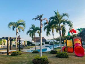 un resort con piscina con scivolo e palme di Enjoy a beautiful beach house in Panamá a Río Hato