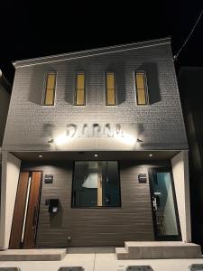 a building with a sign on the front of it at Guest House DARUMA in Anan