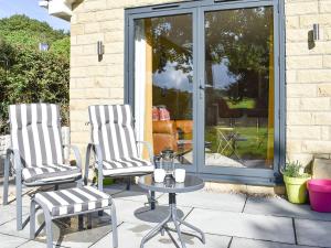 two chairs and a table on a patio at Stone Cottage in Wingerworth