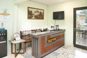 a room with a reception desk and a tv at Panorama İnn Residence Batu Mitra RedDoorz in Batu