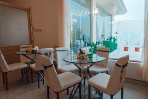 سيلين وسيلينا في Al Barkah: غرفة طعام مع طاولتين وكراسي ونافذة