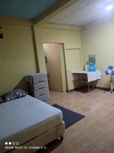 une chambre avec un lit et un bureau dans l'établissement IsmaRoom, à El Remate