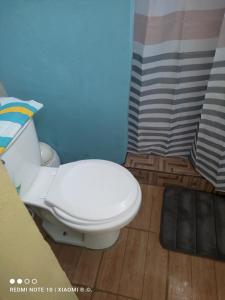 une salle de bain avec des toilettes blanches dans une chambre dans l'établissement IsmaRoom, à El Remate