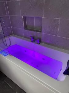 a bath tub with a purple dye on it at Number 6 in Fort William +30 photos