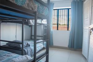 a room with two bunk beds and a window at Las Carmelas, Airport Juan Santamaría, Alajuela, San José in Alajuela City