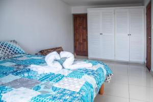 1 dormitorio con 1 cama y 2 toallas en forma de corazón en Las Carmelas, Airport Juan Santamaría, Alajuela, San José, en Alajuela