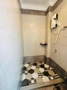 a bathroom with a black and white tiled floor at Memory Boutique Hotel in Semporna