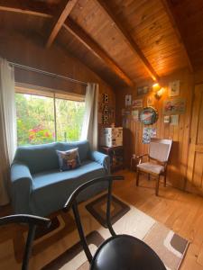 a living room with a blue couch and a window at CASA PALAFITO Interior. in Pucón