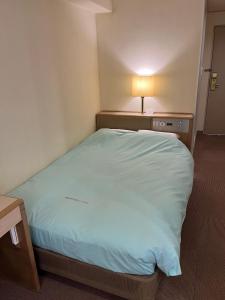 東京にあるオリンピックイン神田のランプ付きの客室の大型ベッド1台