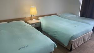 Säng eller sängar i ett rum på Olympic Inn Kanda