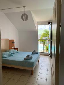a bedroom with a bed with towels on it at Maison Agréable Familiale in Saint-François +28 photos