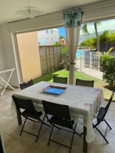 a table with chairs and a white table cloth on a patio at Maison Agréable Familiale in Saint-François