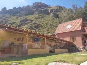 a building with a mountain in the background at Yuyay Wasi Bungalows in Urubamba