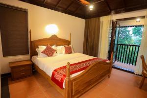 a bedroom with a large bed and a balcony at Heaven Inn Munnar in Munnar