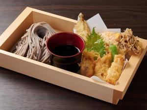 a box of food with pasta and a cup of sauce at APA Hotel Higashi Umeda Minami Morimachi Ekimae in Osaka