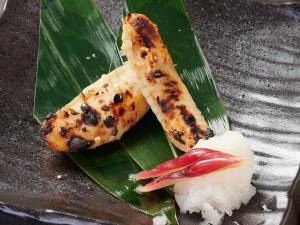 un plato de comida con pescado y arroz en una hoja de plátano en APA Hotel Higashi-Umeda Minami-morimachi-Ekimae en Osaka