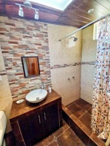 een badkamer met een wastafel en een douche bij Yuyay Wasi Bungalows in Urubamba