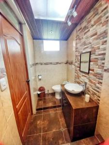 a bathroom with a sink and a toilet in it at Yuyay Wasi Bungalows in Urubamba