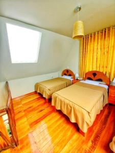 um quarto com 2 camas e uma janela em Yuyay Wasi Bungalows em Urubamba