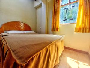 a bedroom with a large bed with a large window at Yuyay Wasi Bungalows in Urubamba
