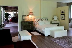 a bedroom with a white bed and a dresser with a lamp at VillaMilla deluxe en-suite room in Mae Haad