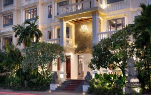 a large building with stairs and trees in front of it at The Elephant in Siem Reap