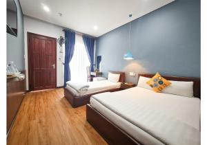 a hotel room with two beds and a chair at Quan Quan Hotel in Danang