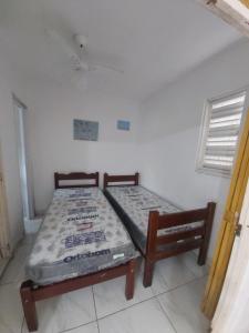 een slaapkamer met een bed en een bank in een kamer bij Apartamento em Maranduba - Ubatuba in Ubatuba