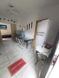 een keuken met een koelkast en een tafel en stoelen bij Apartamento em Maranduba - Ubatuba in Ubatuba