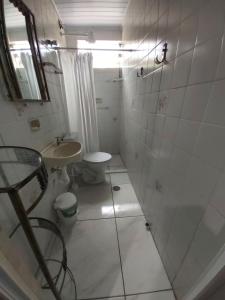 een badkamer met een douche, een wastafel en een toilet bij Apartamento em Maranduba - Ubatuba in Ubatuba