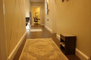 a hallway with a rug and a room with a table at Cozy apartment, two bedroom, full kitchen in Riyadh