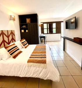 1 dormitorio con 1 cama y TV en la pared en Pancha Mama Hotel Boutique en Villa de Leyva