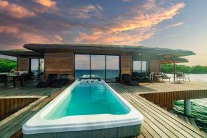 una casa con piscina en una terraza de madera en Eco-Lodge Bocas Coral Reef - Over water villa & birds house, en Botabite