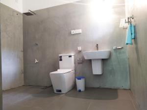 a bathroom with a toilet and a sink at Savendro in Hikkaduwa
