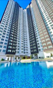 uma grande piscina em frente a dois edifícios altos em Amber Cove Melaka Sea View by Stayrene em Malaca