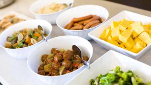 a table topped with bowls of different types of food at Toyoko Inn Osaka Itami Airport in Toyonaka