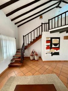 sala de estar con escalera y alfombra en Pancha Mama Hotel Boutique en Villa de Leyva