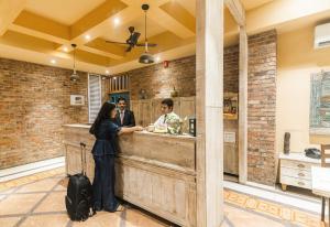 a woman standing at a counter in a restaurant at Bougainvilla Apartment in Surat