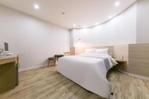 Rúm í herbergi á Daejeon Yuseong Hotel Dret