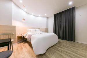 Rúm í herbergi á Daejeon Yuseong Hotel Dret