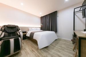 Rúm í herbergi á Daejeon Yuseong Hotel Dret