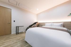 Rúm í herbergi á Daejeon Yuseong Hotel Dret