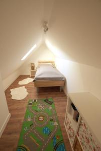 a small attic room with a bed and a green rug at Borkum in Dorum Neufeld