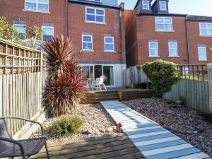 ein Garten vor einem Backsteingebäude in der Unterkunft Sea Pebbles in Weymouth